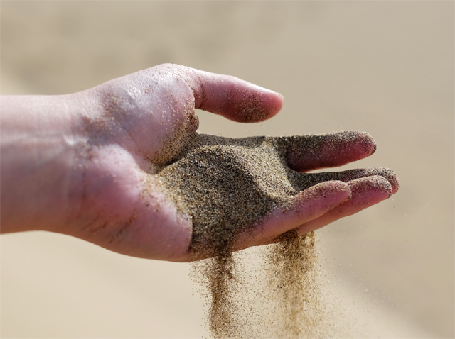 Freepik Brauner Sand verrinnt in einer menschlichen Hand