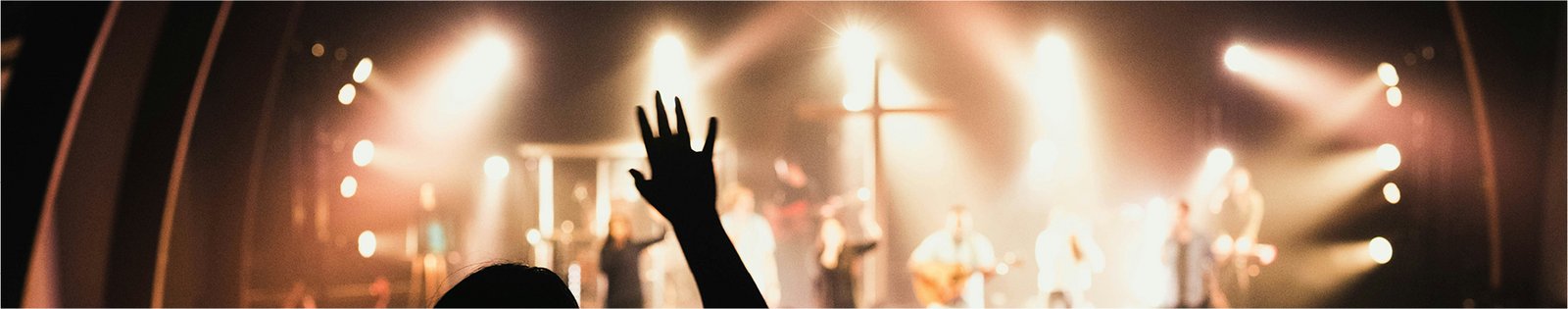 Szene aus einem Lobpreiskonzert, Bühne mit Scheinwerfern und Betende