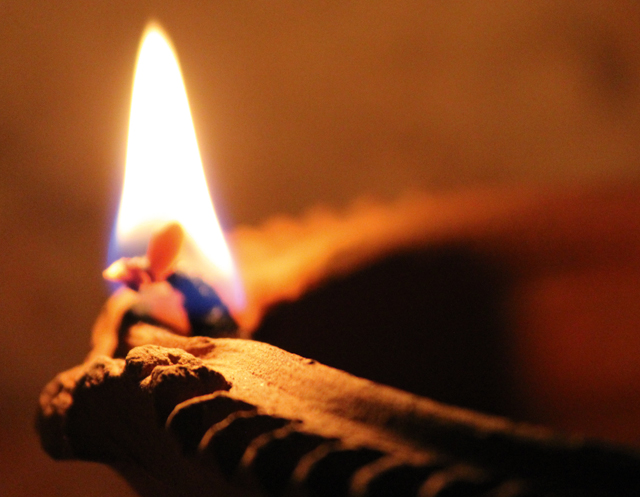 Eine Flamme brennt in einem Öllicht
