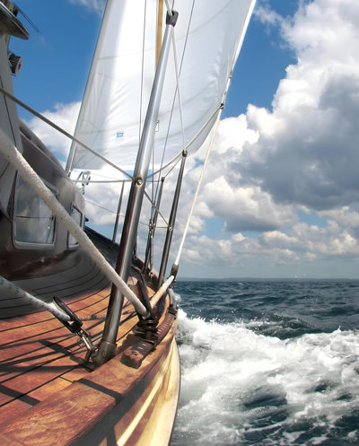 Ein Segelboot auf dem Meer und Wolken bei blauem Himmel